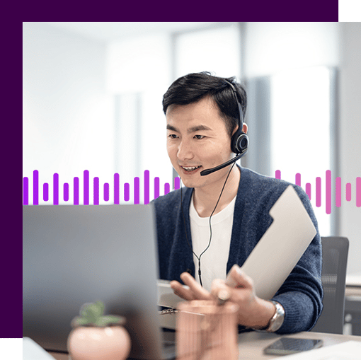 Person sitting at a computer with a headset on looking at an open file folder. 