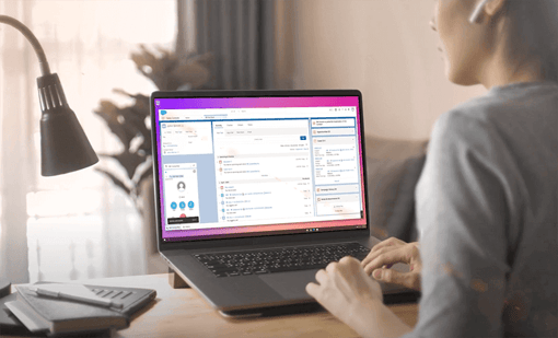 VBC for Salesforce video still contact center agent at her desk with laptop open showing Vonage Business Communications embedded within Salesforce