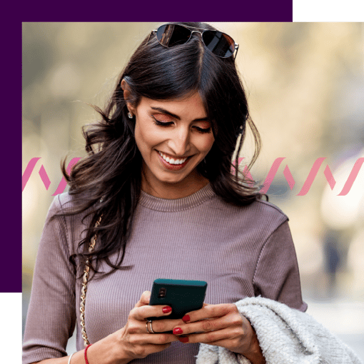 Photo of a woman looking at a mobile phone and smiling