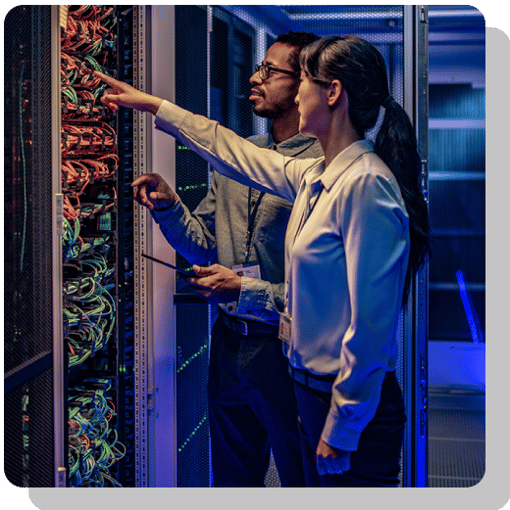Two IT professionals inspecting a networking panel with like a thousand wires