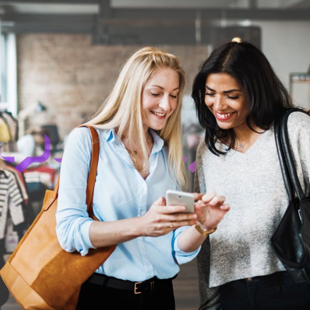 API SEO Conversational Marketing Blog Header Photo of two women in a store shopping. They are smiling as one woman shows the other something on her cell phone.