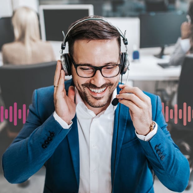 SEO Inbound Calls Blog Header Photo of a a smiling call center agent talking to a customer through his phone headset. In the background, a series of small vertical lines runs across the frame, representing communication.