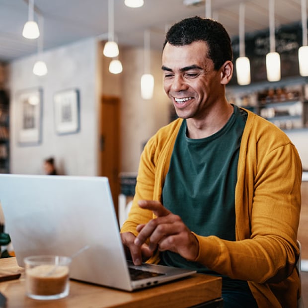 Photo of a business man working remotely on his laptop