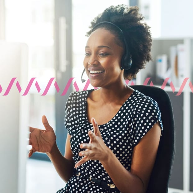 UC SEO What Is Call Center Blog Header Photo of a smiling call center agent gesturing with her hands as she talks to a customer over her headset. In the background, a series of small "sound waves" run across the frame.