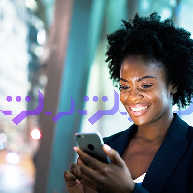 VoIP Texting Blog Header Photo of a smiling woman typing a text into her cell phone.