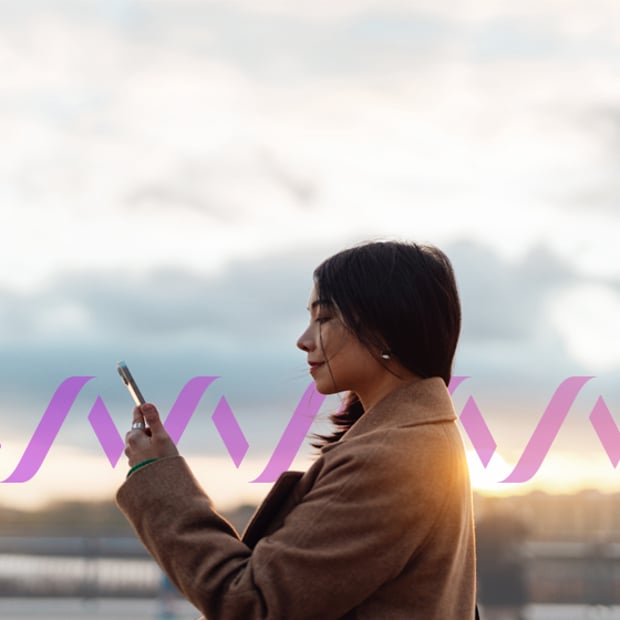 SMS to RCS Migration blog image Confident young Asian businesswoman with smartphone standing against the sky. Concept of a Rich Communication Services message.