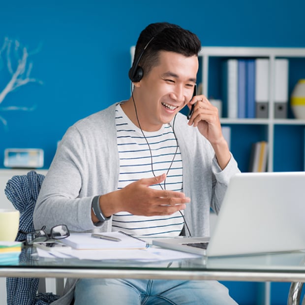 UC 8 Benefits of SD-WAN article Thumbnail Photo of small-business owner using a laptop for a video meeting and talking on a headset.