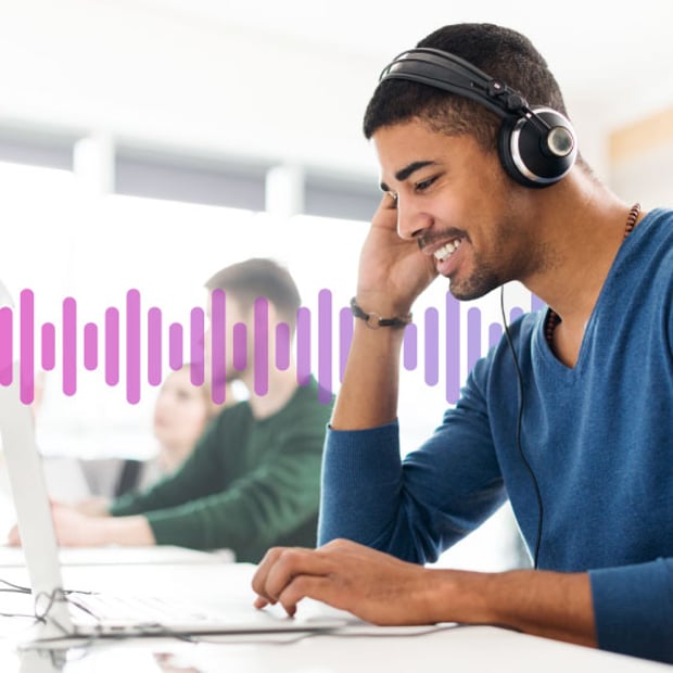 10-Reasons-Integrate-CC-SCV-blog Man wearing a headset and looking at a laptop while working in an office.