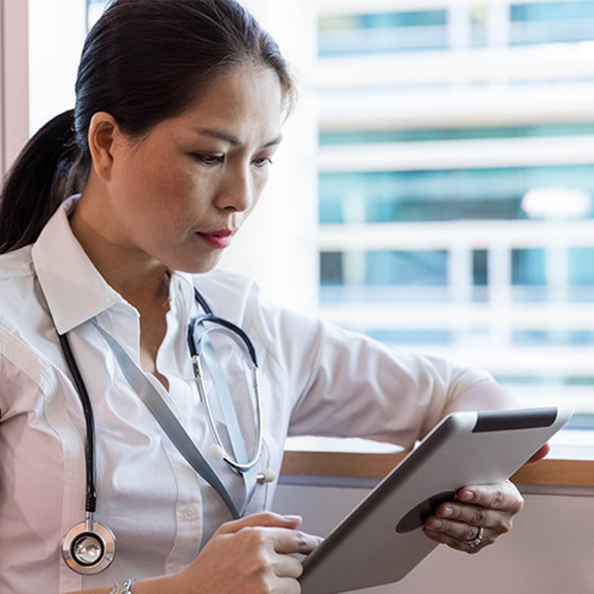 Female Asian Doctor Female Asian doctor looking at a smart device while on her shift