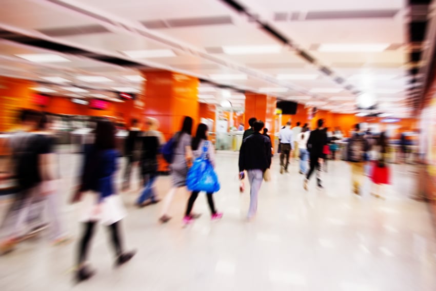 10 Customer Expectation Trends Header Colorful photo of a crowd of shoppers in a mall. The photo is blurred to show movement.