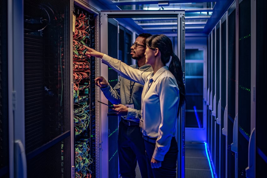 Goals IT Department Header Image Photo of two IT team members in a server room discussing and troubleshooting the network system