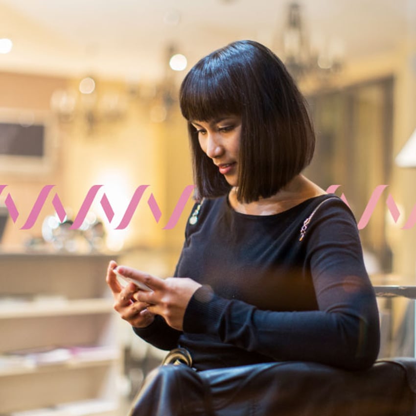 Photo of woman using her cell phone to work outside of an office setting