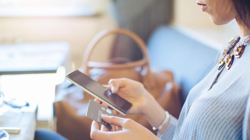 Woman using credit card for retail shopping on mobile device