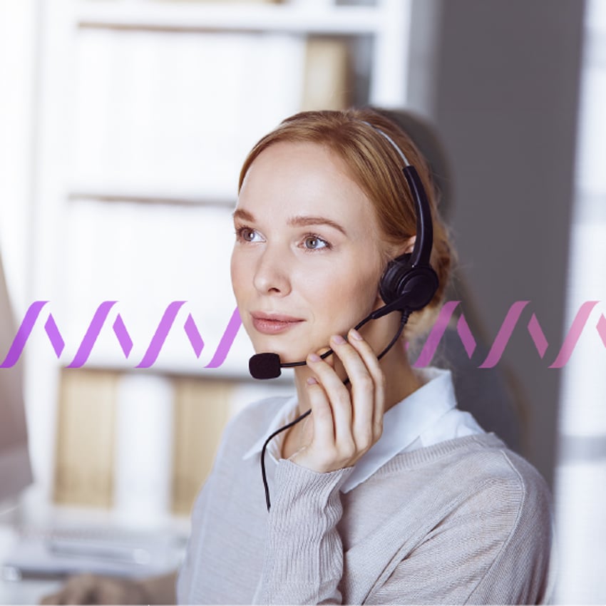 Photo of a female employee in an office setting wearing a headset.