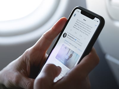 Image of a person using a smartphone on a plane.