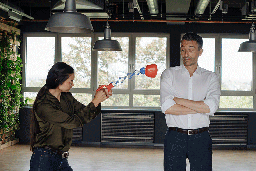 Knocking Out Obstacles Header Image Humorous photo of a woman playfully using a toy boxing glove to punch a man