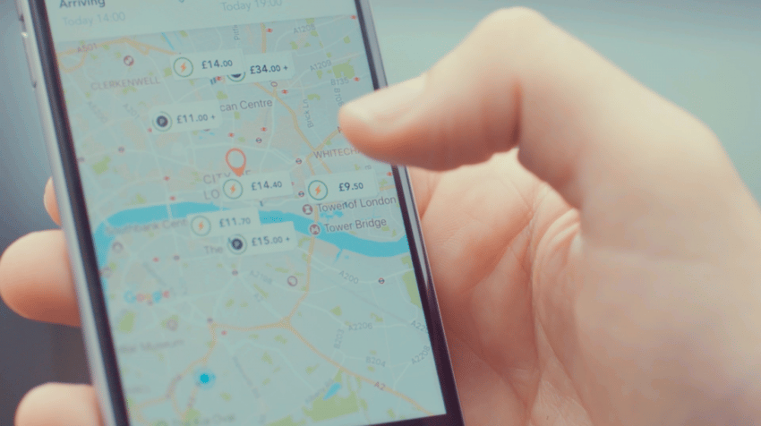 Hand holding a mobile phone with JustPark app open showing map